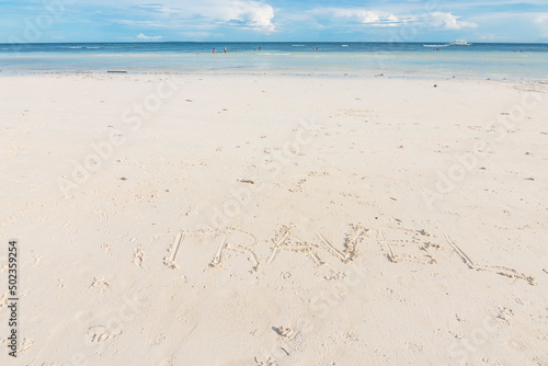 A travel word written in the white powdery sand. At Dumaluan Beach in Panglao, Bohol. Vacation and tropical beach background. photo