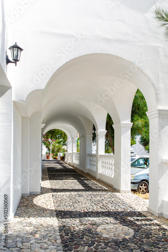 Fotografie, Obraz Arched corridor with columns in a traditional Greek white house.