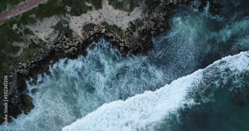 Aerial drone footage of the big ocean waves hitting rock
