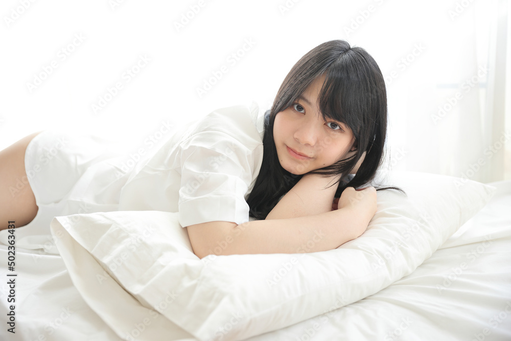 Beautiful young woman waking up in the morning at white bedroom Beautiful young woman waking up in the morning at white bedroom