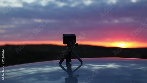 Slow motion shot of tripod camera agaisnt sunset photo