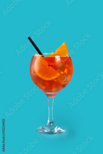 Glass of aperol spritz cocktail on blue background