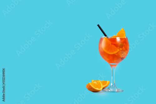 Glass of aperol spritz cocktail on blue background