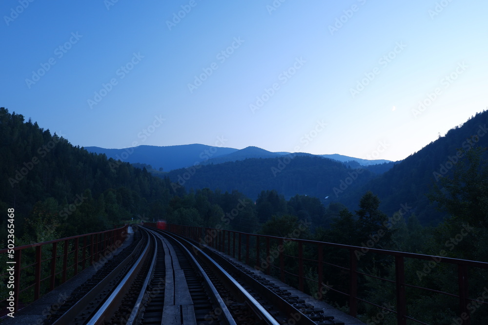 Fototapeta premium Railway among the Ukrainian mountains at sunset