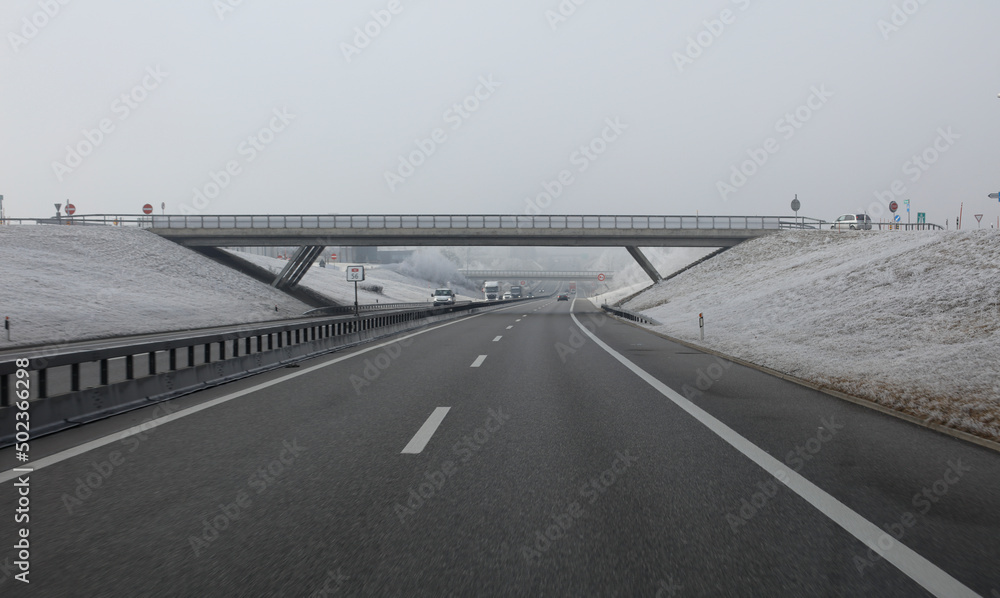Fototapeta premium Arbres enneigés sur l'autoroute avec un pont