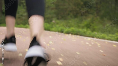 A girl runs in the woods close-up to her legs from behind