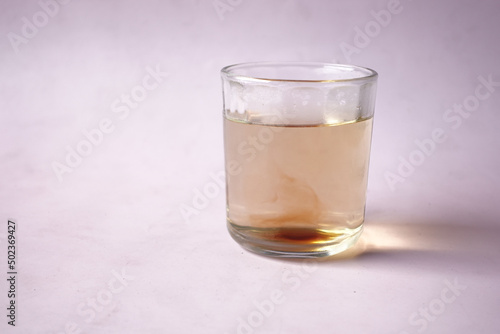 dirty glass of water on purple background 