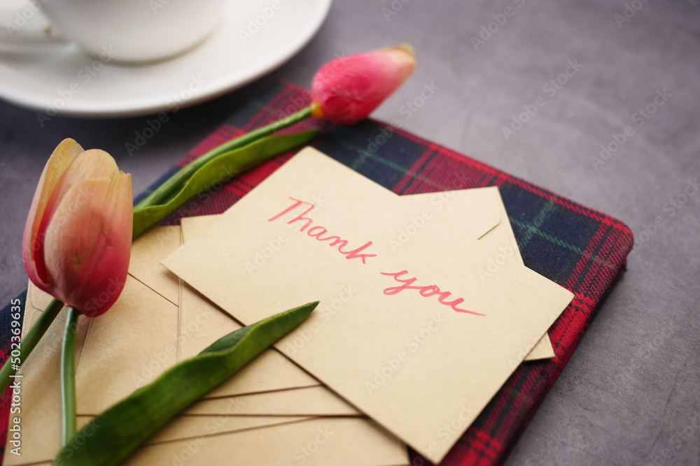 Fototapeta premium thank you message, envelope tulip flower on table 