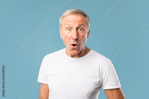 Surprised mature man staring at camera at studio