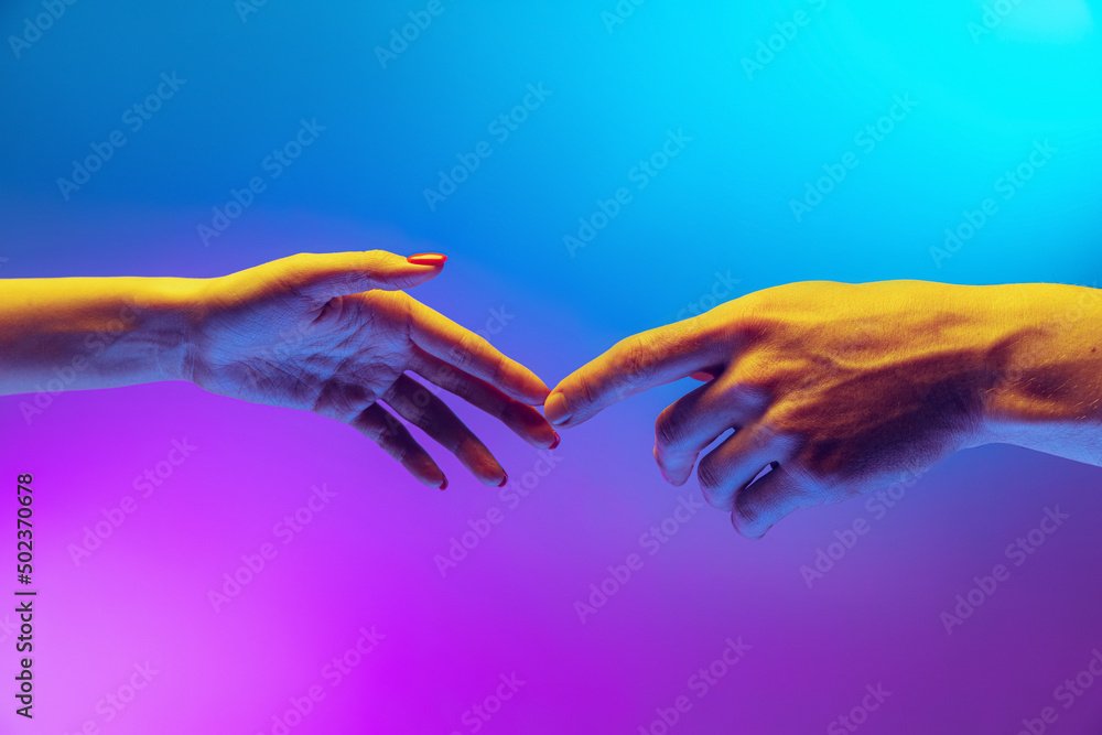 Two human hands touch each other isolated on gradient blue-purple background in neon light. Concept of human relation, togetherness, symbolism, culture and history - obrazy, fototapety, plakaty 