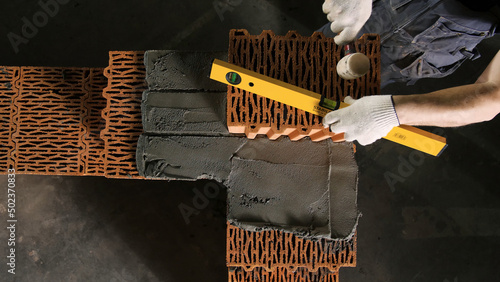 Obraz na plátne Close-up of Builder using leveler for brickwork