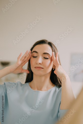 girl doctor in a blue coat massaging her face
