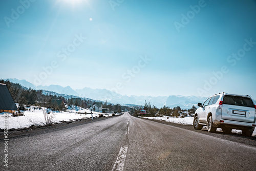 4x4 vehicle parked on side of a road in Žabljak, Montenegro with Durmitor mountains in background