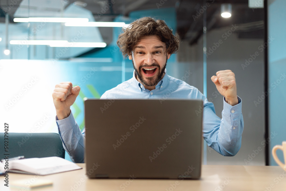 Excited businessman using pc celebrating success shaking fists screaming yes Excited businessman using pc celebrating success shaking fists screaming yes