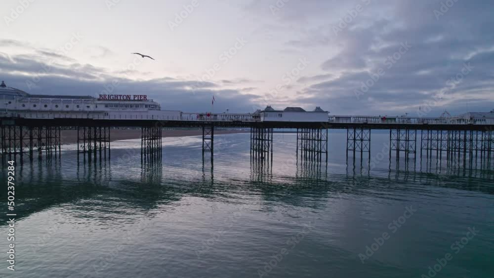 Drone flies backwards to reveal full length of Brighton Palace Pier and town at dawn, UK Drone flies backwards to reveal full length of Brighton Palace Pier and town at dawn, UK
