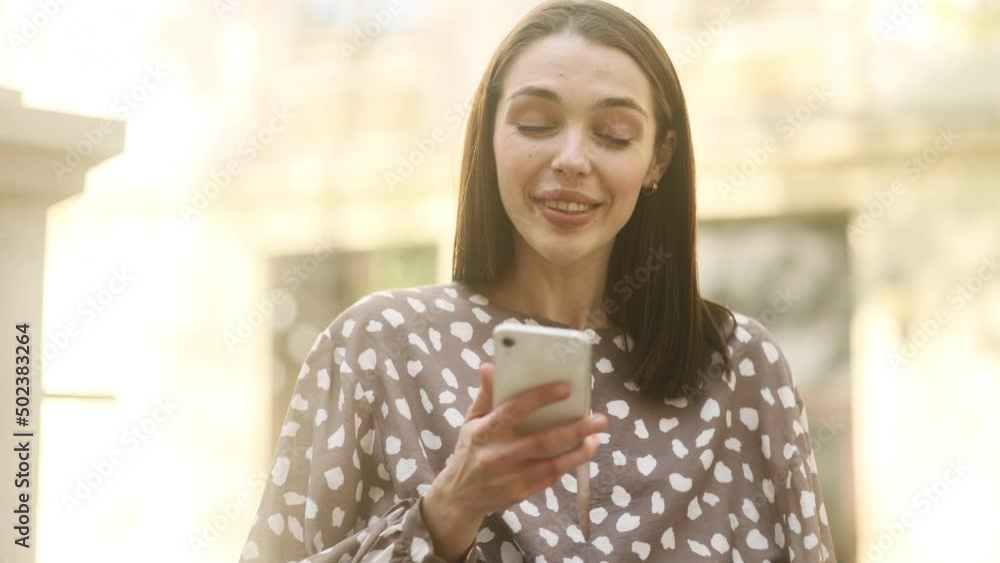 Young caucasian woman paying with credit card on smart phone in the street. Happy customer. Young caucasian woman paying with credit card on smart phone in the street. Happy customer.