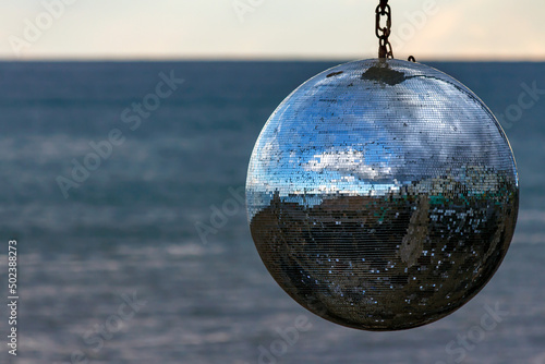 Closeup of a mirrorball with the reflection of the beach on the surface in Brighton, England photo