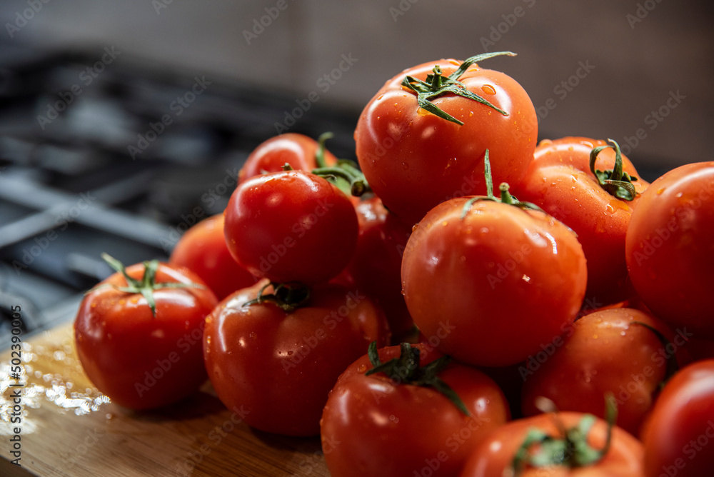 Umyte błyszczące pomidory w kuchni na desce do krojenia - obrazy, fototapety, plakaty 