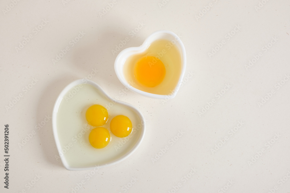 quail eggs nad chiken egg in heart shaped bowls on texture backgrund quail eggs nad chiken egg in heart shaped bowls on texture backgrund