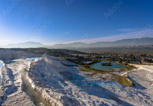 Beautiful scene of a big water pool accessed by rough rocks in Travertines of Pamukkale, Turkey photo