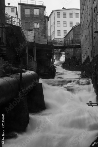 Vertical shot of the stream of the river in grayscale in Kvarndammen i Molndal photo