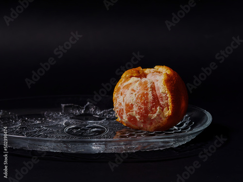 Closeup shot of half-peeled mandarin orange on a black background photo