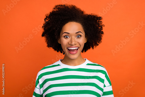 Portrait of attractive amazed cheerful girl having fun great news isolated over bright orange color background