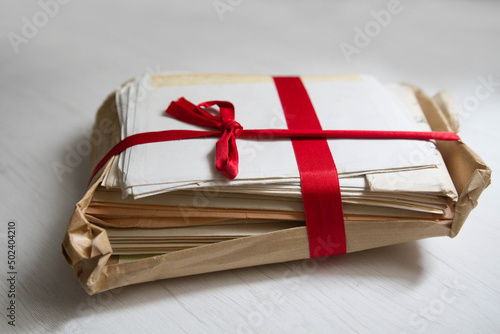 Closeup of the pile of letters tied with red ribbon. Memories, love letters. photo