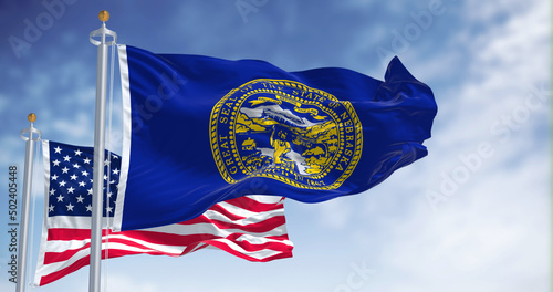 The Nebraska state flag waving along with the national flag of the United States of America