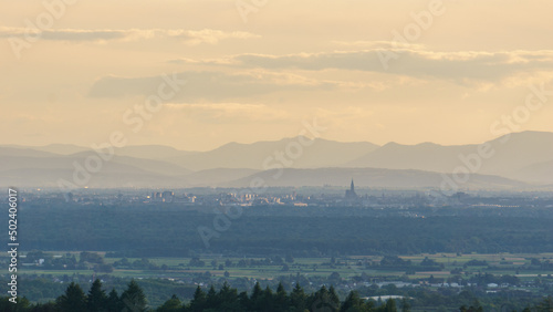 Distant view of city Strasbourg, France including popular cathedral and Vosges mountains in background from Black Forest, Germany
