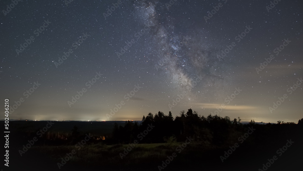 The galactic core of Milky Way over silhouette of trees on the Schliffkopf, Black Forest, Germany The galactic core of Milky Way over silhouette of trees on the Schliffkopf, Black Forest, Germany