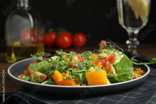 Delicious salad with lentils and vegetables served on wooden table, closeup