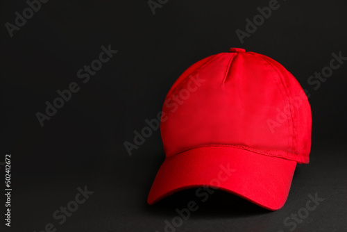 Baseball cap on black background, space for text