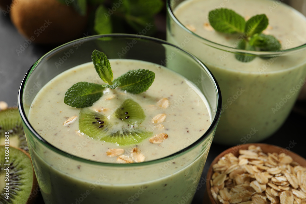 Glasses of tasty kiwi smoothie with oatmeal on table, closeup Glasses of tasty kiwi smoothie with oatmeal on table, closeup