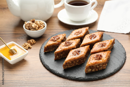 Delicious sweet baklava with walnuts and honey on wooden table