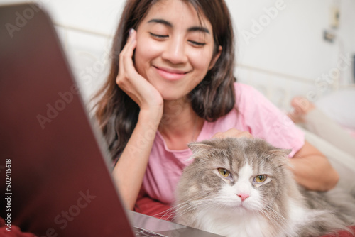 Young Asian woman working from home with her cat