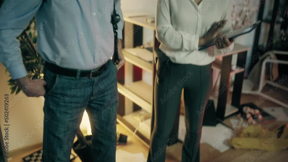 Male detective discussing murder case with female colleague at crime scene Male detective discussing murder case with female colleague at crime scene