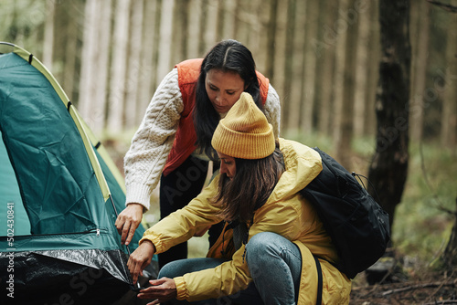 Foto Women putting up a tent in the forest