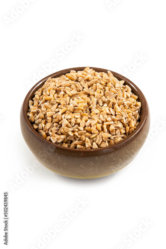 Handful of whole wheat cereals in a mini ceramic bowl on a white background,top view.