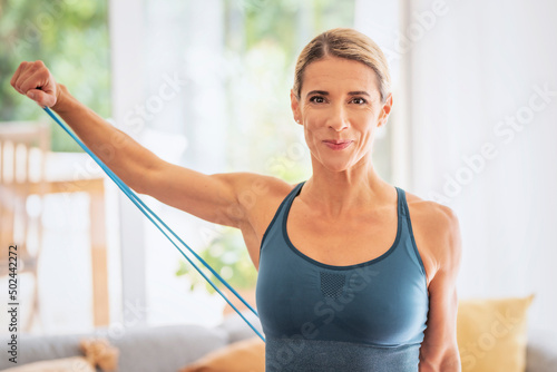 Attractive woman exercising with a power band at home photo