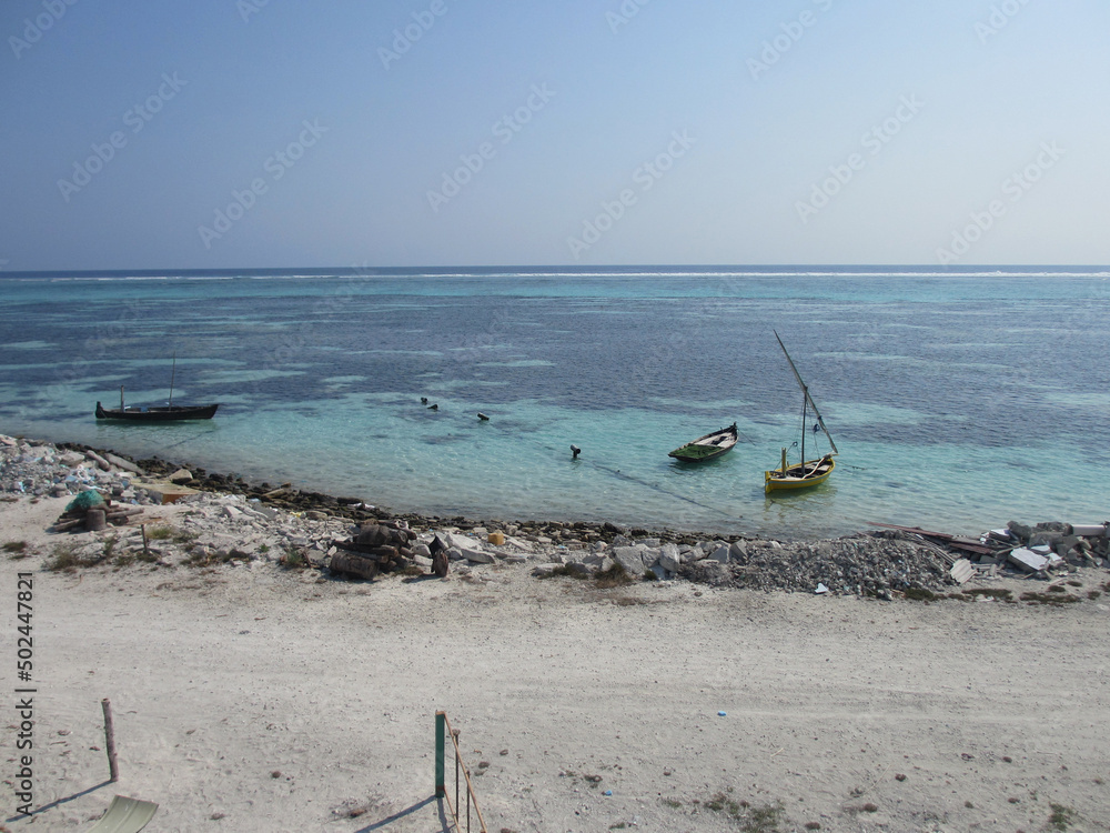 Maldives. Indian Ocean. Fishing island. White sand, blue water. Old boats in the ocean. Maldives. Indian Ocean. Fishing island. White sand, blue water. Old boats in the ocean.