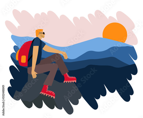 Traveler with a backpack sits on a rock and looks at the mountains during the dawn