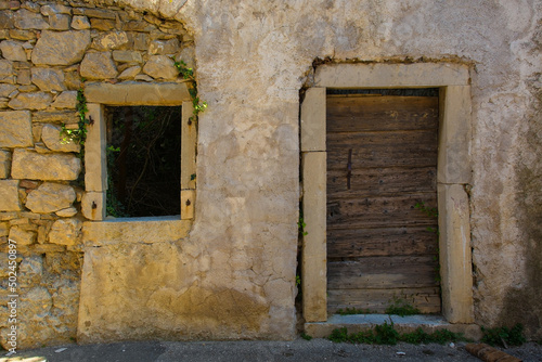 An old wooden door and empty window in an historic derelict farm building in the village of Roc near Buzet in Istria, western Croatia   © dragoncello