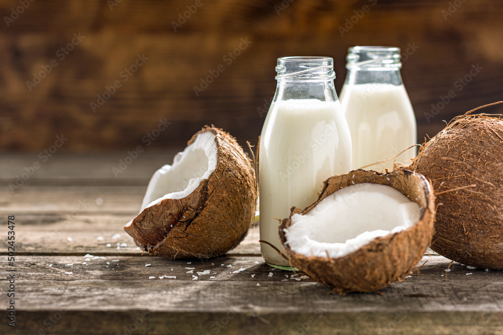 Vegan non dairy healthy or fermented drink. Coconut kefir in glass bottle on wooden table. healthy drink, food concept Vegan non dairy healthy or fermented drink. Coconut kefir in glass bottle on wooden table. healthy drink, food concept