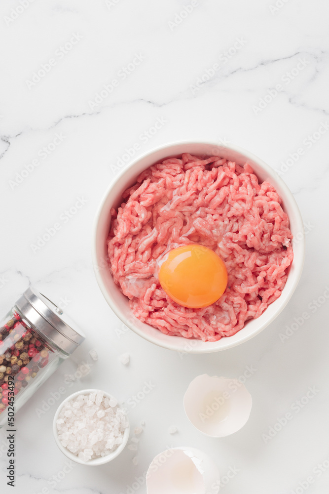 Cutlet ingredients beef farce meat with egg in a plate Cutlet ingredients beef farce meat with egg in a plate