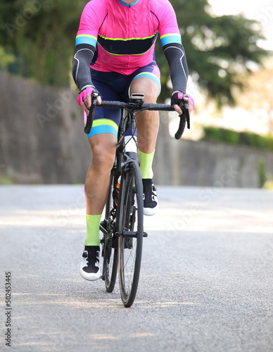 Cyclist with sportswear on a racing bike pedaling photo