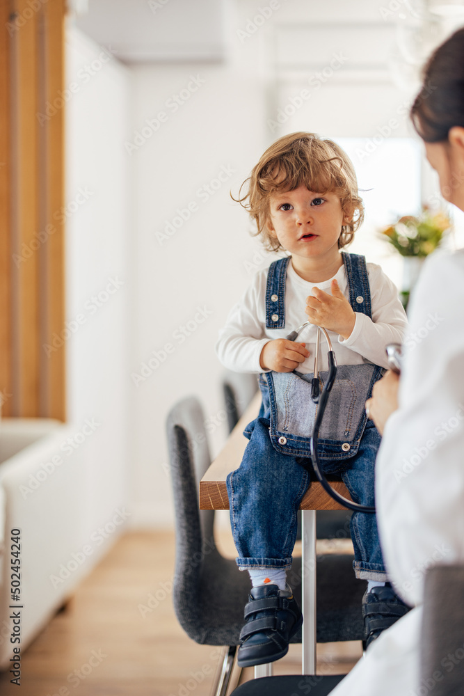 Portrait of a male toddler, sitting in front of a pediatrician d
