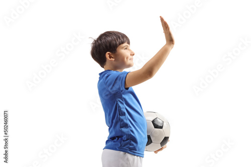 Profile shot of a football boy with a soccer ball gesturing high five