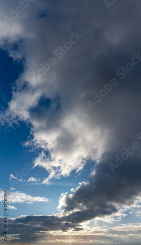 Fantastic thunderclouds at sunrise, vertical panorama