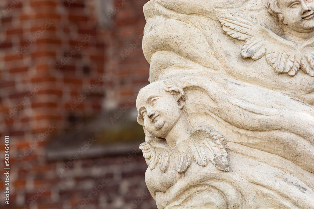 Putto (Putti) among the clouds - lower fragment of a rococo statue - Our Lady next to the Church of St. Stanisław in Nowy Korczyn, Poland Putto (Putti) among the clouds - lower fragment of a rococo statue - Our Lady next to the Church of St. Stanisław in Nowy Korczyn, Poland